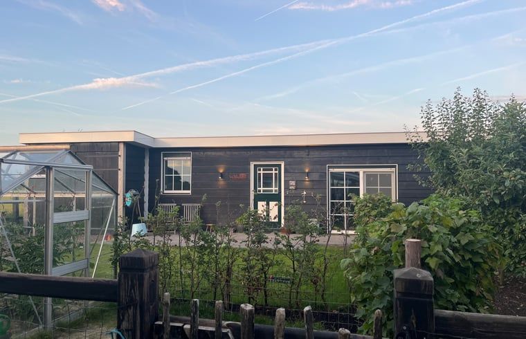 Buitenzijde van Vakantiehuis in Lewedorp bij zonsondergang, serene omgeving in Zuid-Beveland, Zeeland.