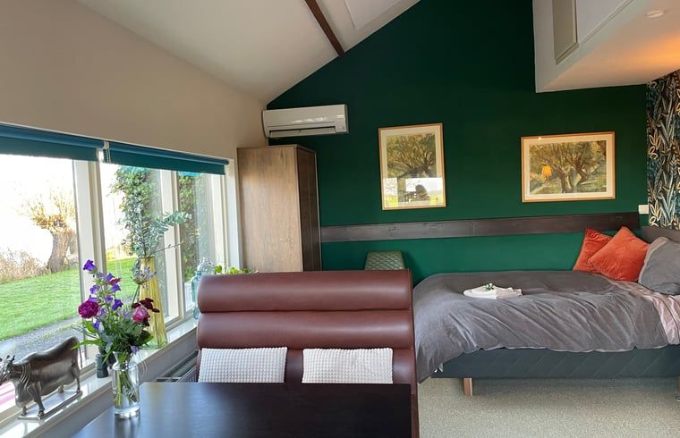 Schlafzimmer in Ferienhaus in Brandwijk, Alblasserwaard mit moderner Einrichtung und Gartenblick.