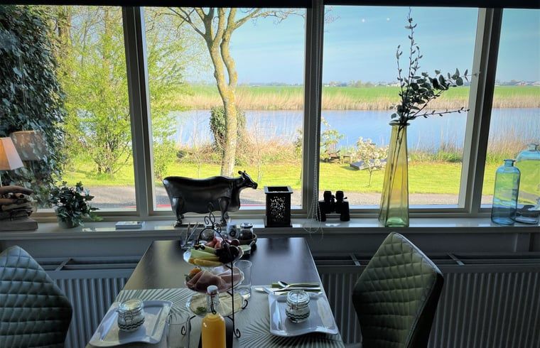 Fruehstueck mit Blick auf den Fluss im Cottage in Brandwijk, Brandwijk, Suedholland.
