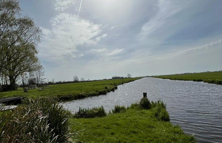 Landschap rondom Huisje in Stolwijk, vakantiehuis in Zuid-Holland met uitgestrekte velden en water.