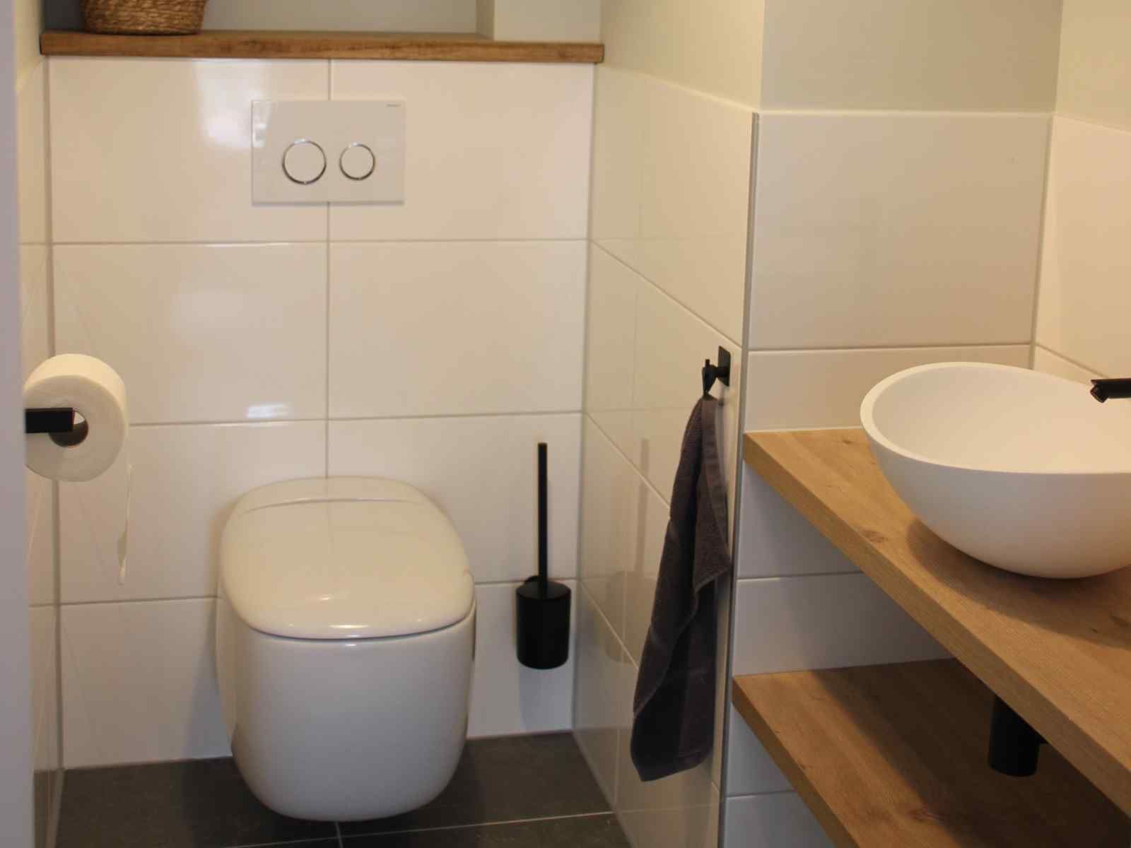 Modernes Badezimmer im Ferienhaus ZH330, Ouddorp, mit stilvollem Spiegel und Waschbecken.