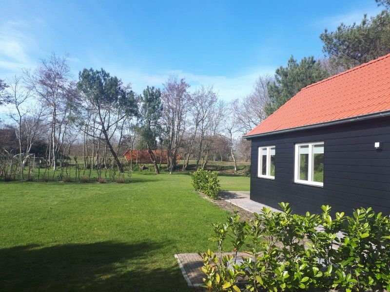 Spacious green garden at vacation home Vrijheid in Ouddorp, Goeree-Overflakkee, South Holland, ideal for relaxation.