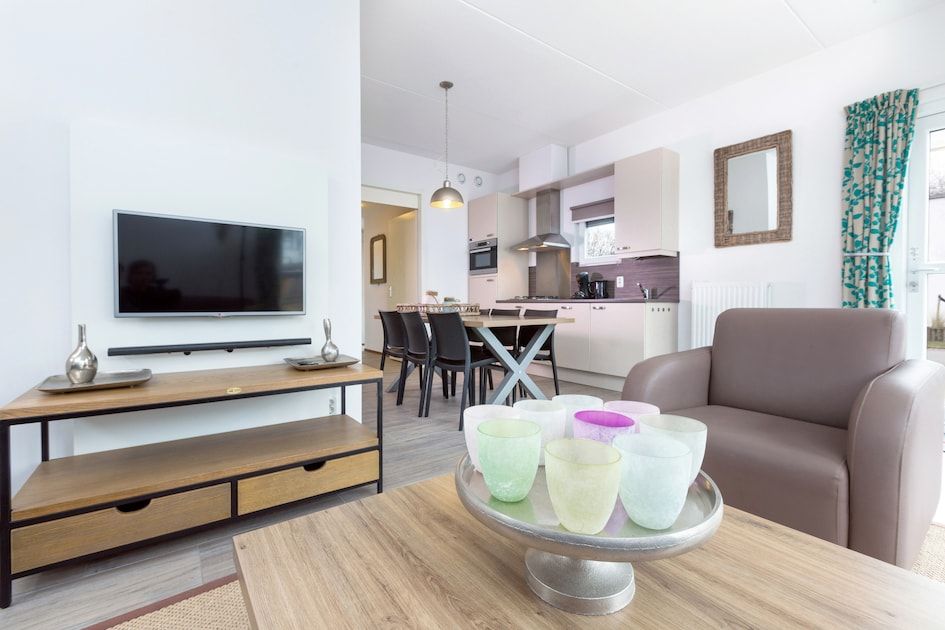 Modernes Wohnzimmer des Bungalows 6C in Ouddorp, Suedholland, mit offener Kueche und gemuetlicher Sitzecke fuer einen entspannten Urlaub.