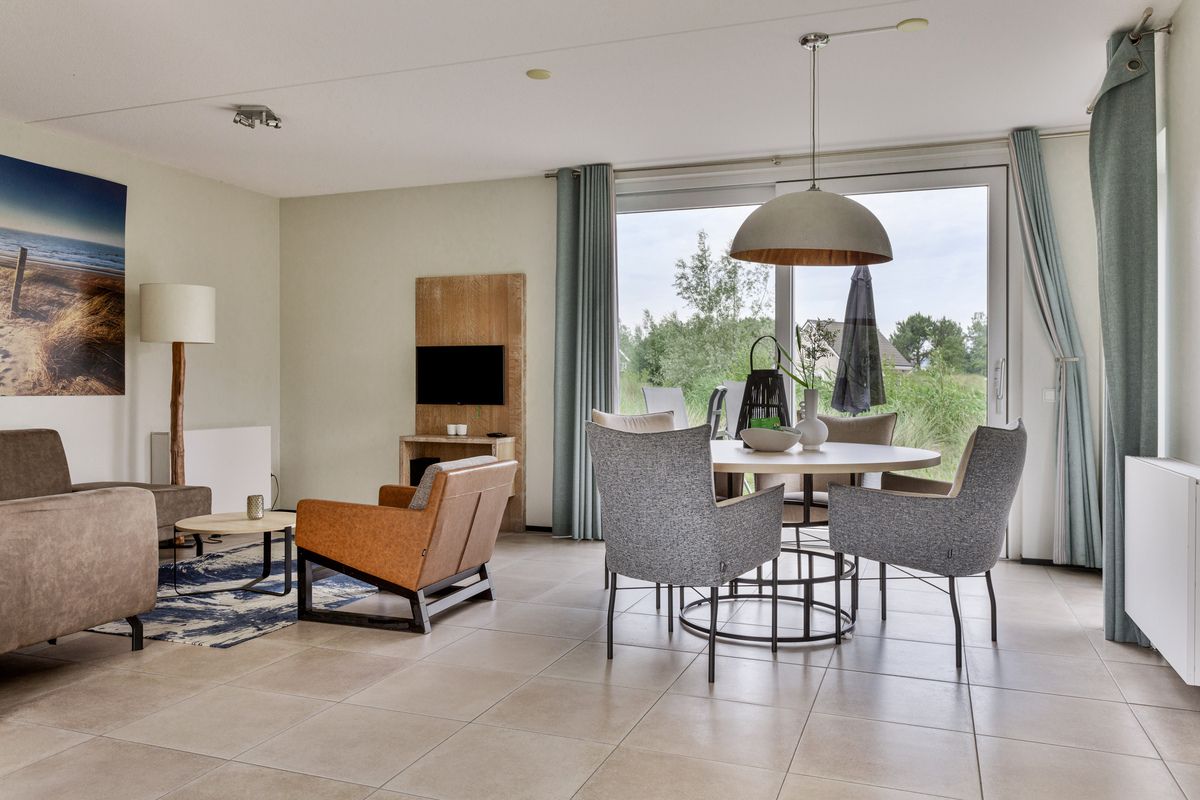 Gemtliches Wohnzimmer in einer Doppelhaushlfte in Ouddorp, Goeree-Overflakkee, Sdholland, mit moderner Einrichtung und Blick auf die Natur.