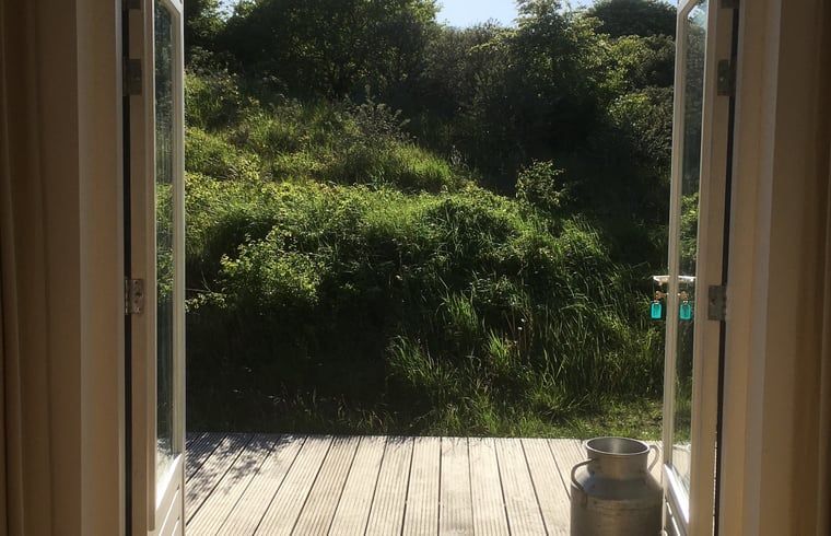 Veranda met uitzicht op groen bij Vakantiehuis in Ouddorp, Goeree-Overflakkee, Zuid-Holland.