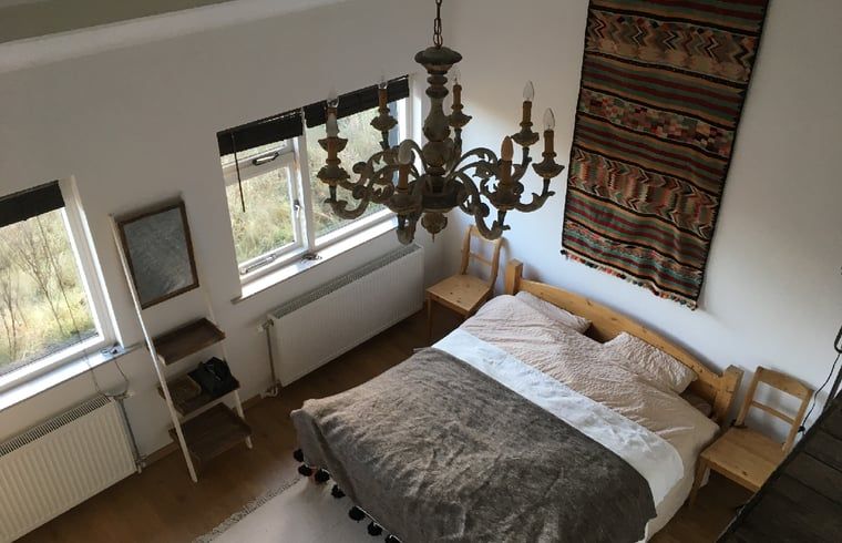 Slaapkamer met kroonluchter in Vakantiehuis in Ouddorp, Goeree-Overflakkee, Zuid-Holland.