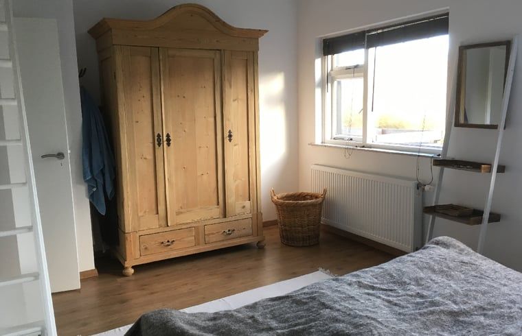 Houten kast in slaapkamer van Vakantiehuis in Ouddorp, Goeree-Overflakkee, Zuid-Holland.