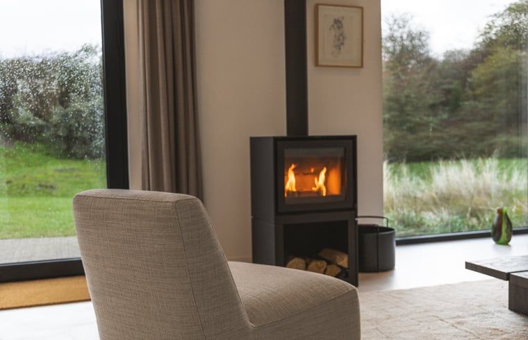 Gemuetliches Wohnzimmer mit Holzofen im Ferienhaus in Ouddorp, Suedholland, ideal zum Entspannen und Geniessen der Aussicht auf die Natur.