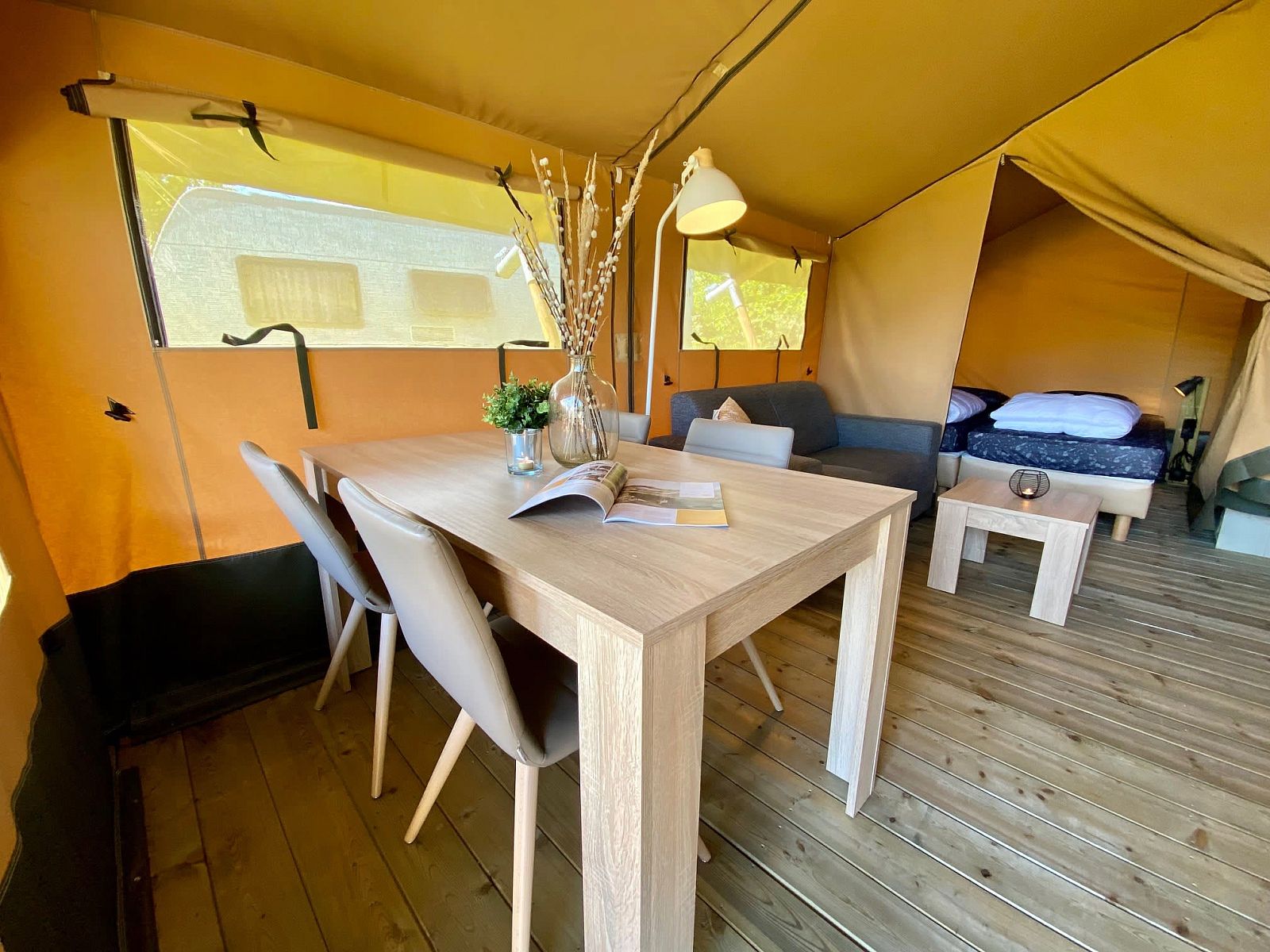 Innenbereich des Safarizeltes Zeeduin in Ouddorp, Goeree-Overflakkee. Gemuetliche Glamping-Lodge mit Holzboden und komfortablem Essbereich.