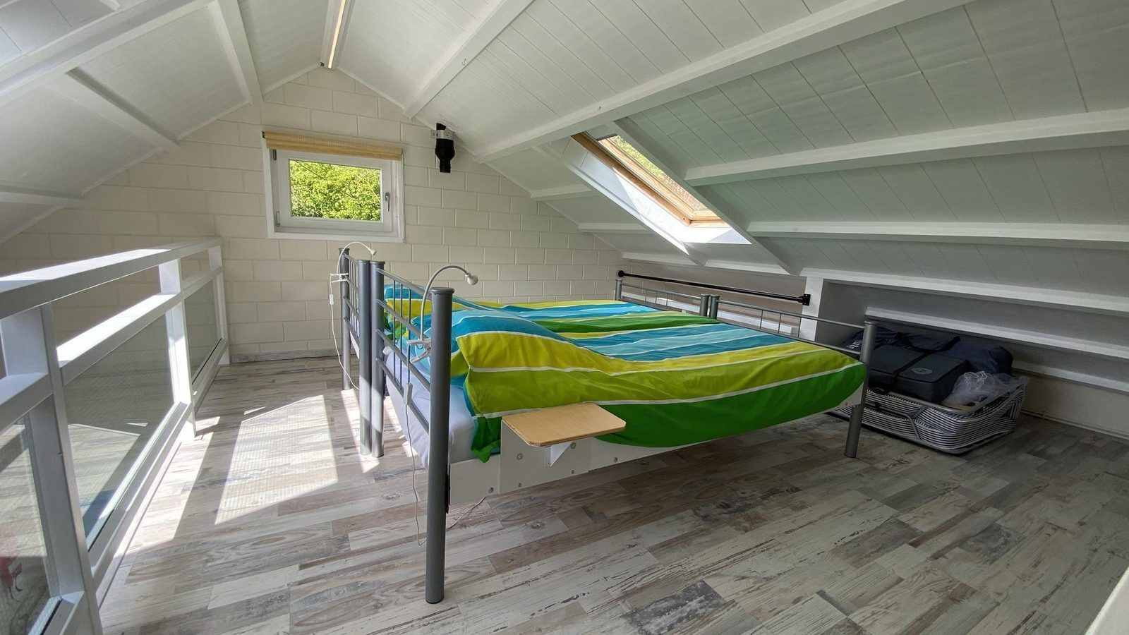 Lichte slaapkamer op zolder van VZ990 Vakantiewoning in Ouddorp met kleurrijk beddengoed in Zuid-Holland.