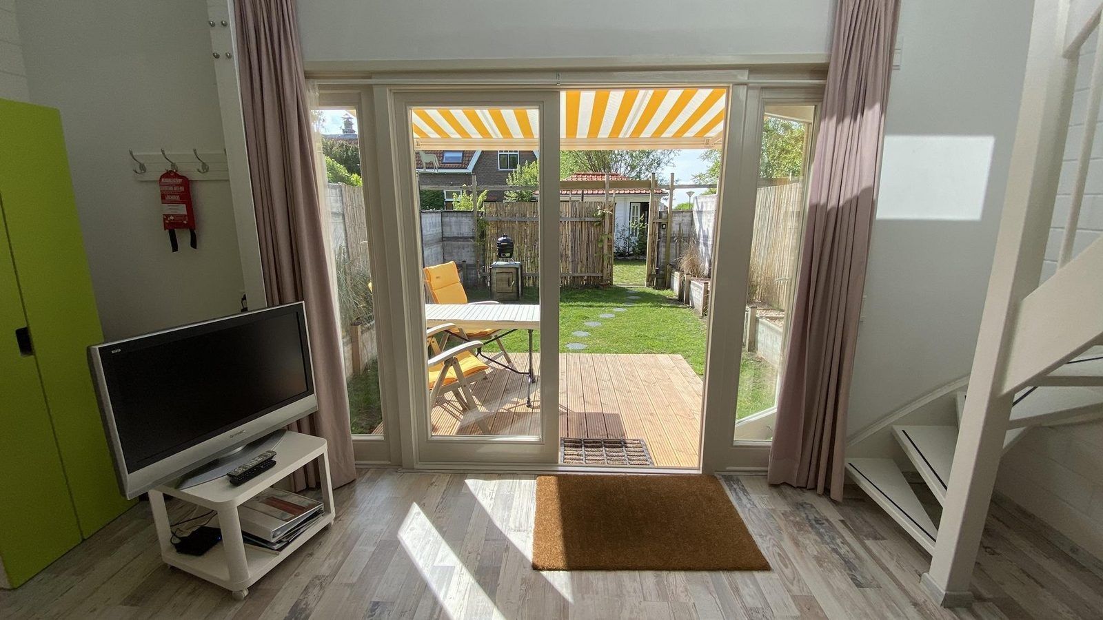 Sonniges Wohnzimmer mit Zugang zum Garten im Ferienhaus VZ991 in Ouddorp, Suedholland.