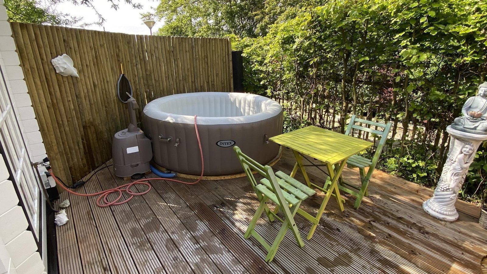 Aussendusche im Ferienhaus VZ991 in Ouddorp, umgeben von natuerlichen Elementen.