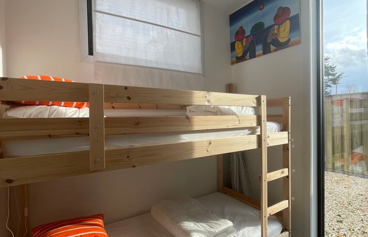 Bright bedroom with bunk beds in Huisje in Ouddorp, a vacation home in Goeree-Overflakkee, South Holland.