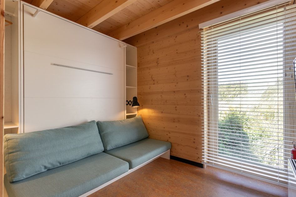 Gezellige binnenruimte van ECO Cottage in Ouddorp, Zuid-Holland, met houten interieur en comfortabele zitbank, ideaal voor ontspanning.