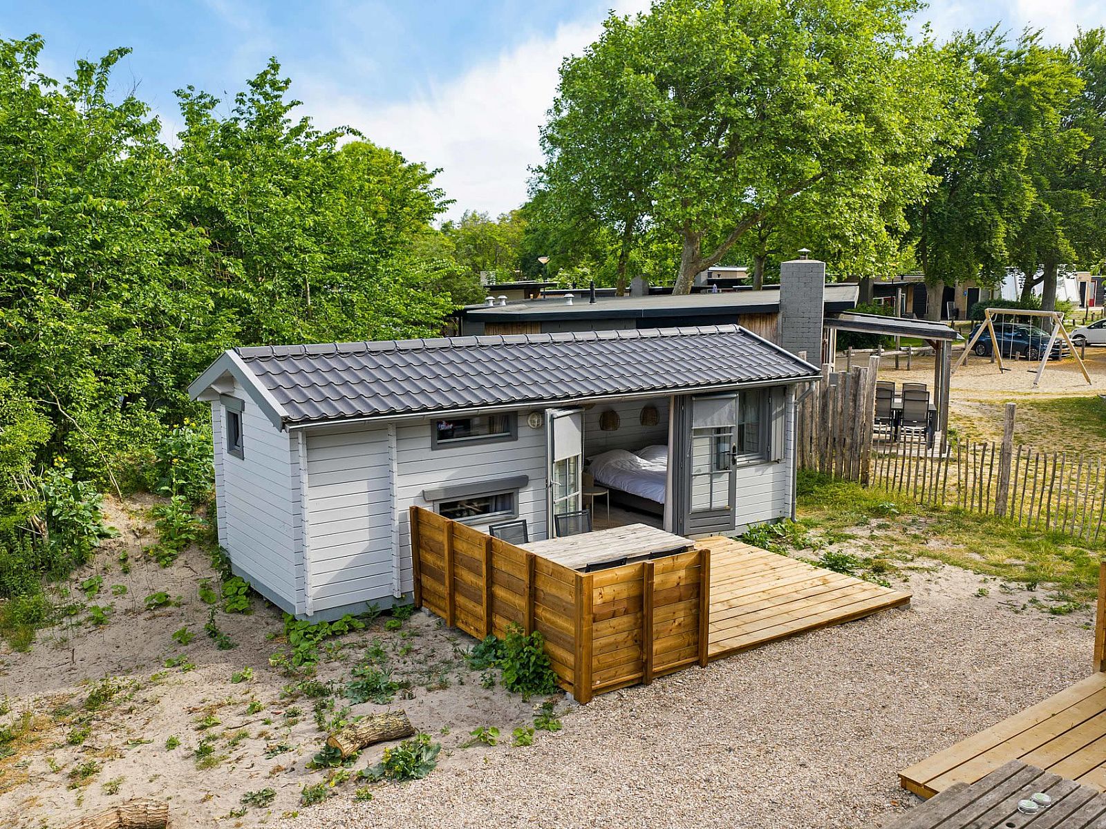 Camping Chalet de Zeekoet in Ouddorp mit gruener Umgebung und einladender Terrasse auf Goeree-Overflakkee, Suedholland.