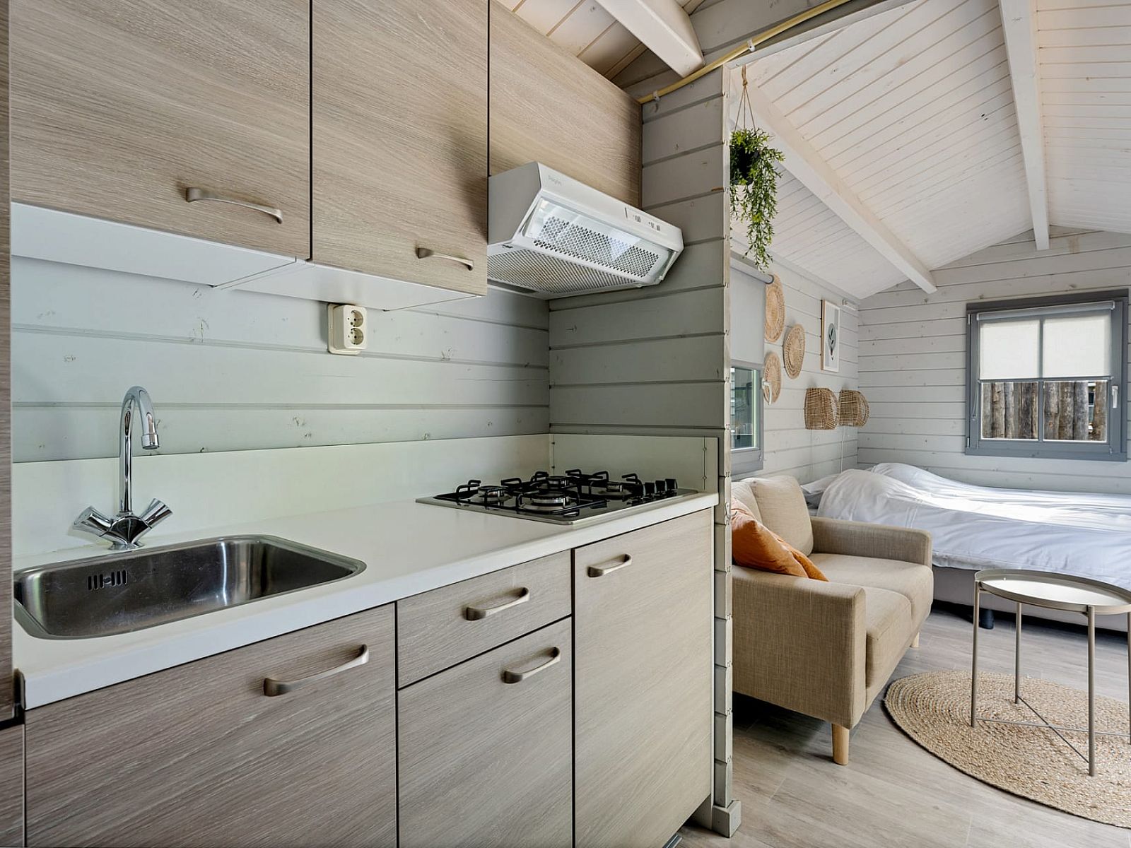 Moderne Kueche des Camping Chalet de Zeekoet in Ouddorp mit Blick auf den gemuetlichen Wohnbereich.