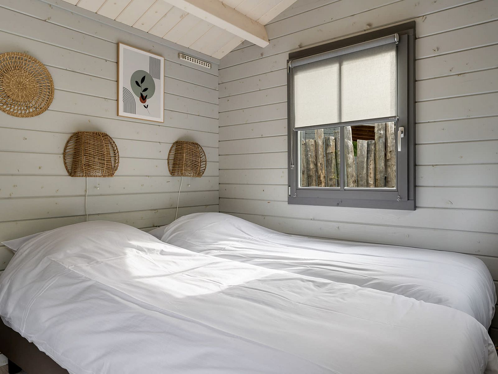 Komfortables Schlafzimmer im Camping Chalet de Zeekoet in Ouddorp mit Blick auf die gruene Umgebung.