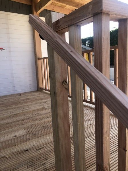 Detail der Holzveranda des Chalets Thuiz in Ouddorp, Suedholland, mit einer warmen, natuerlichen Ausstrahlung.