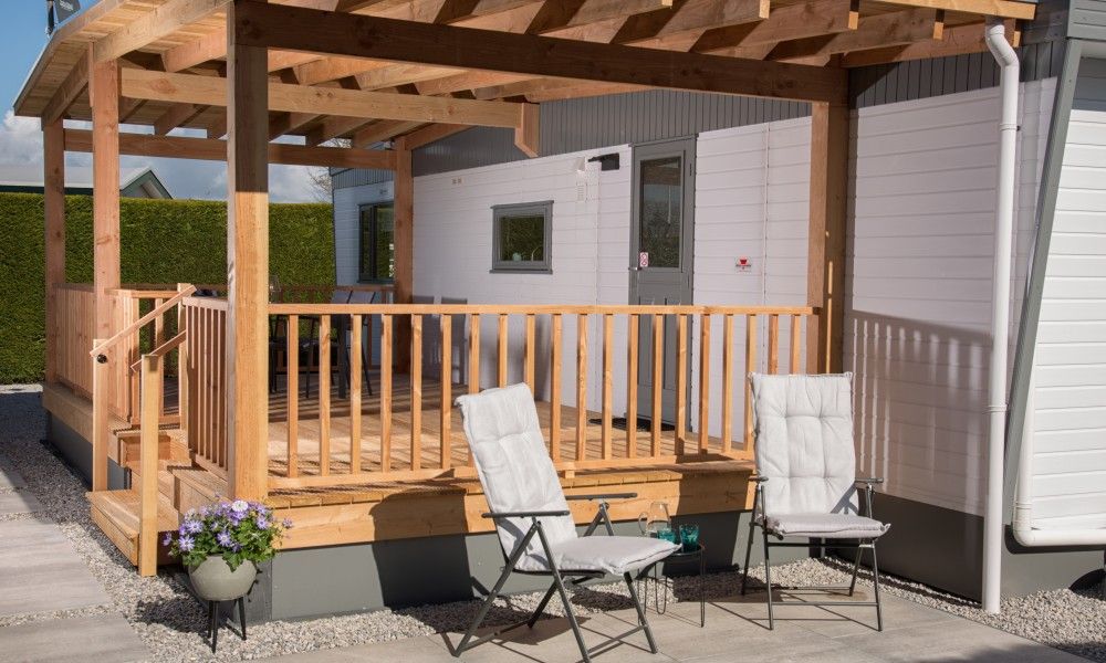Sonnige Terrasse des Chalets Thuiz in Ouddorp, Suedholland, perfekt fuer das Leben im Freien und das Geniessen der Natur.