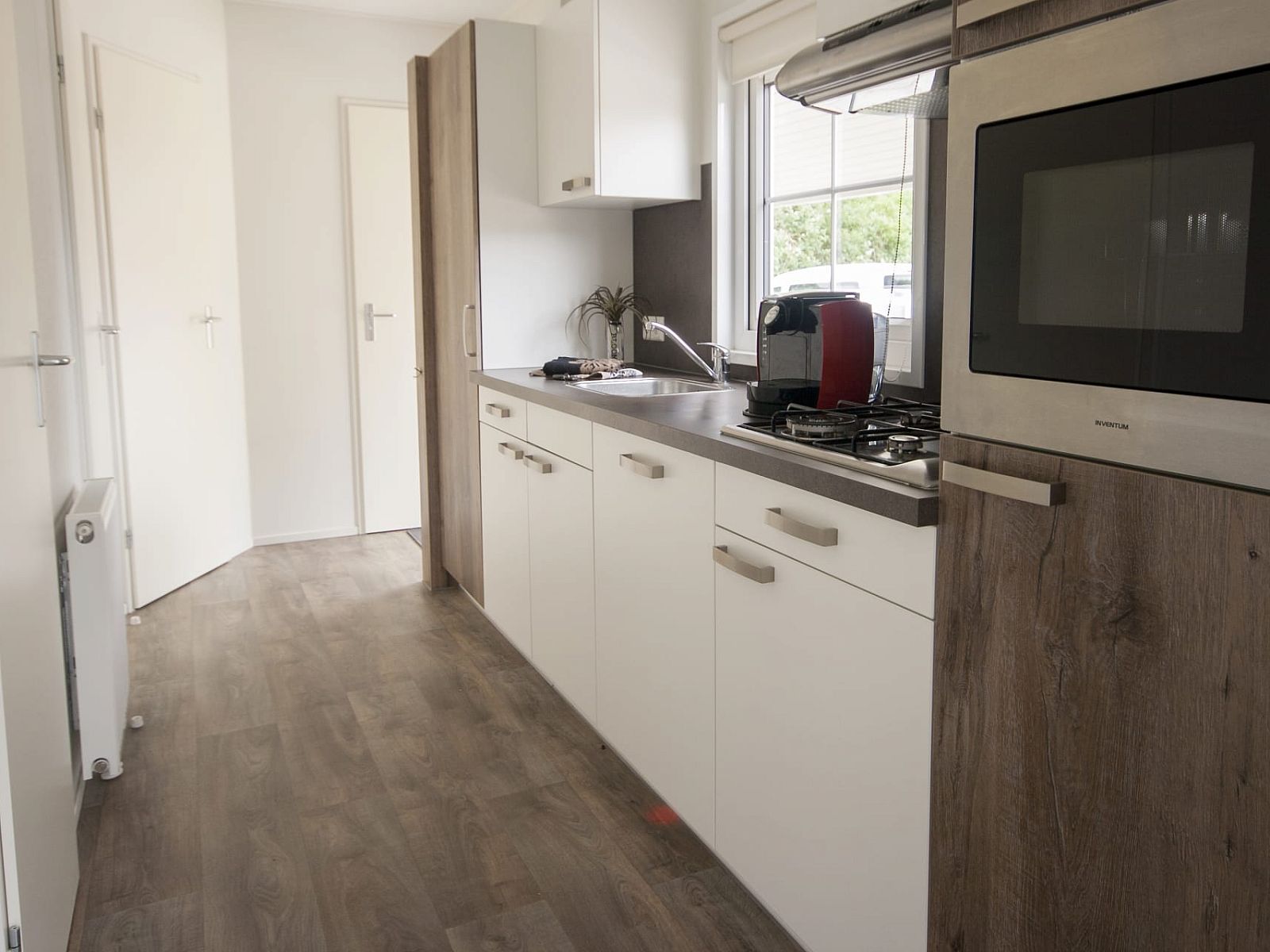 Moderne Kueche im Chalet Ouddorp, Ferienhaus in Ouddorp, Goeree-Overflakkee, Suedholland, mit schlichter Einrichtung und viel natuerlichem Licht.