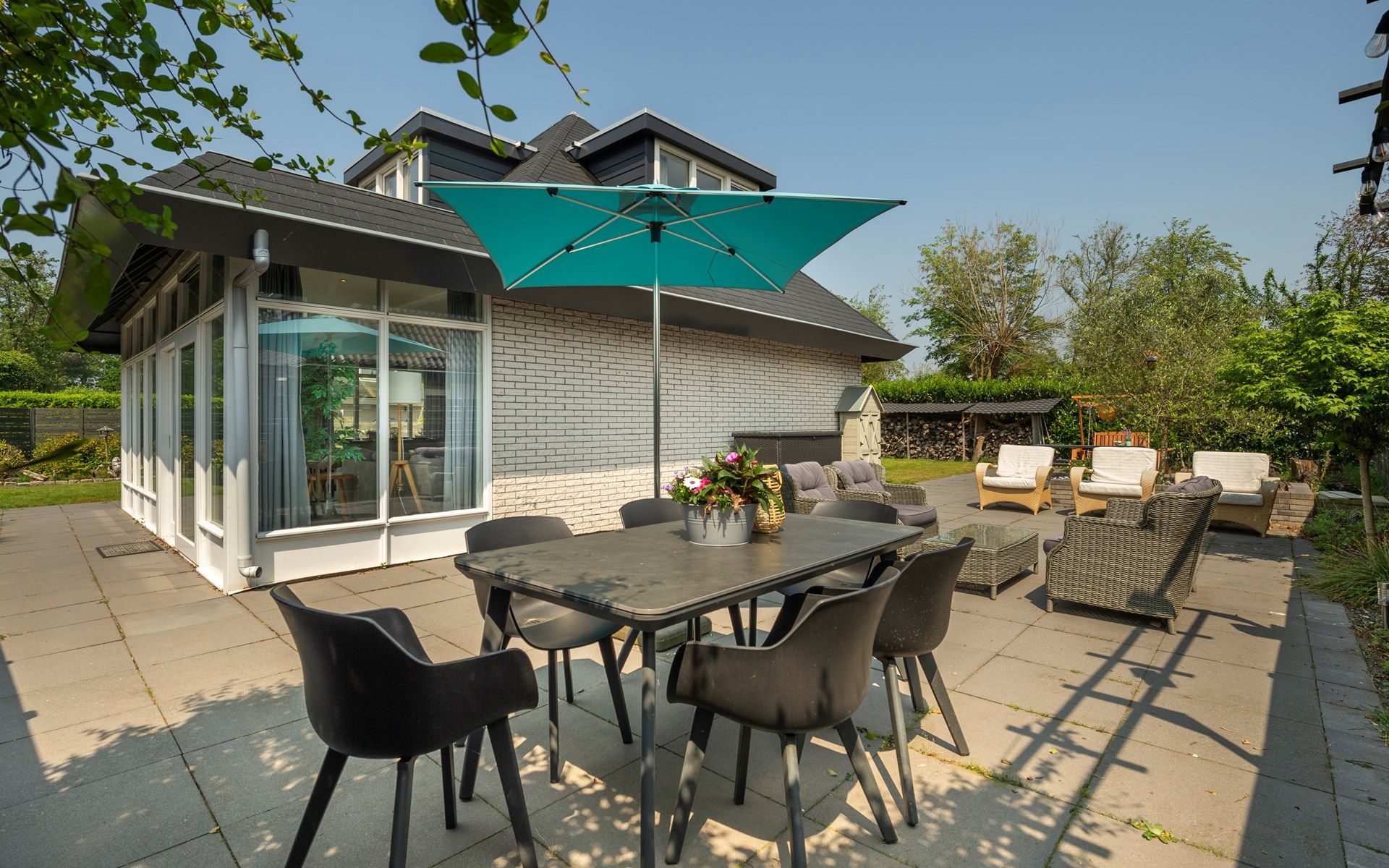Buitenzitje met parasol bij Vakantiewoning De Toekomst 107 'Siesta' in Ouddorp, ideaal voor zomerse dagen.