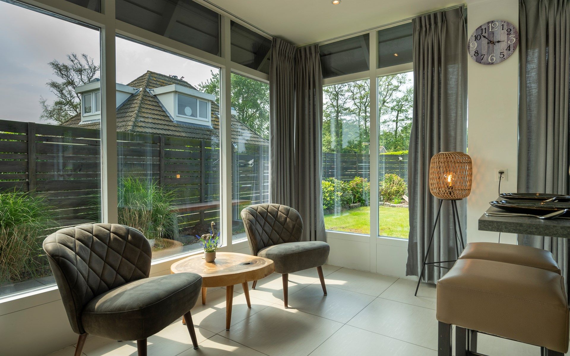 Comfortabele zithoek met uitzicht op de tuin in Vakantiewoning De Toekomst 107 'Siesta' in Ouddorp.