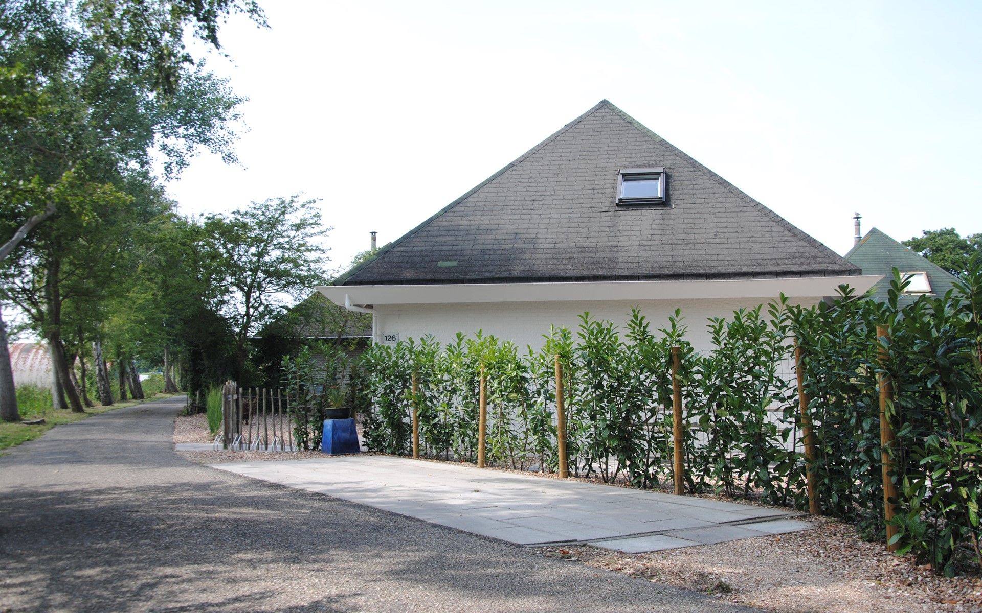 Eingang zum Ferienhaus De Toekomst 126 Beachgarden in Ouddorp mit gruenem Zaun.