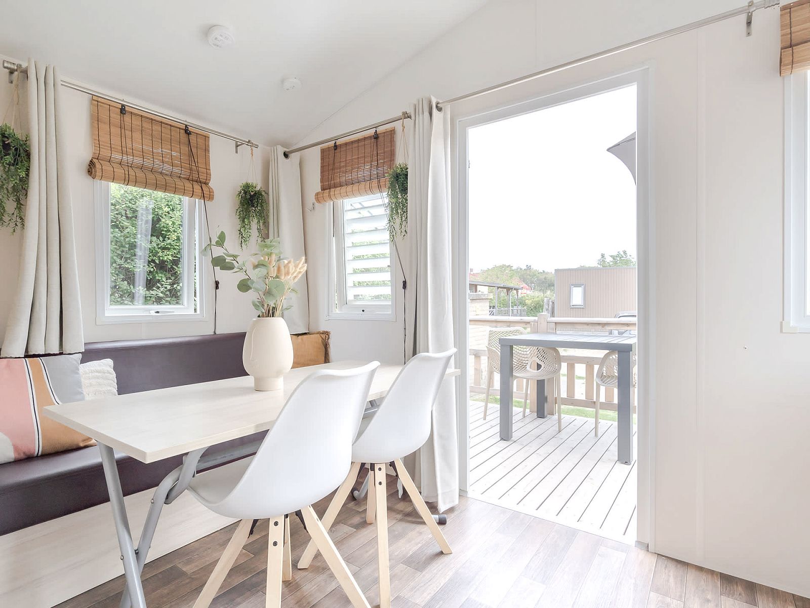 Gemuetlicher Innenbereich des Mobilheims der Kormoran in Ouddorp, Goeree-Overflakkee mit Blick auf die Terrasse und die gruene Umgebung.