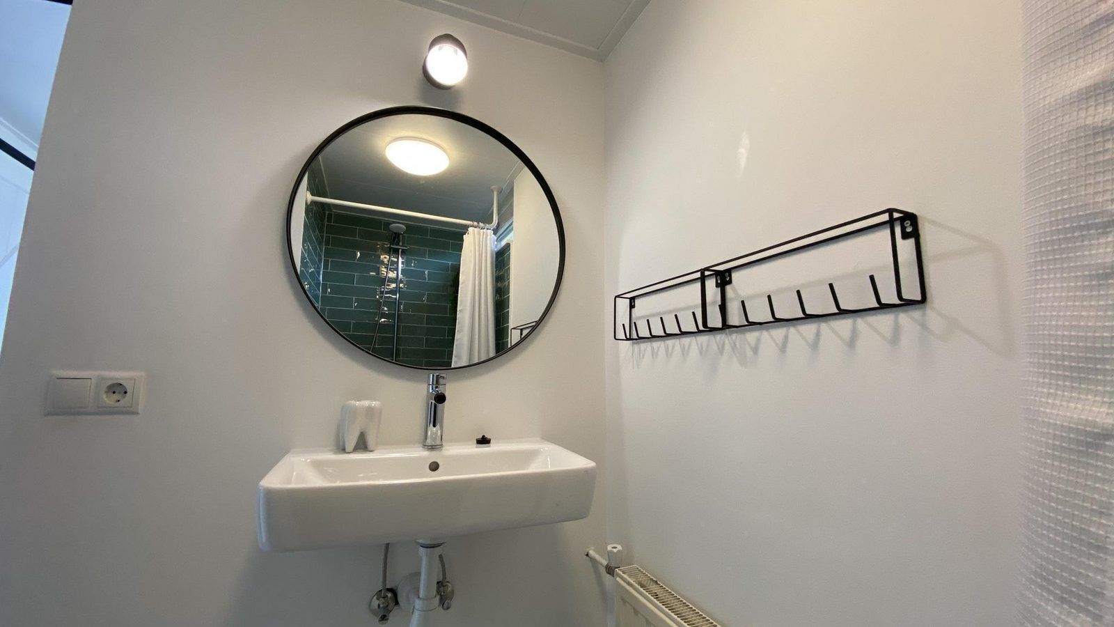 Moderne wastafel en spiegel in de badkamer van VZ934 Bungalow in Ouddorp, gelegen in Zuid-Holland.