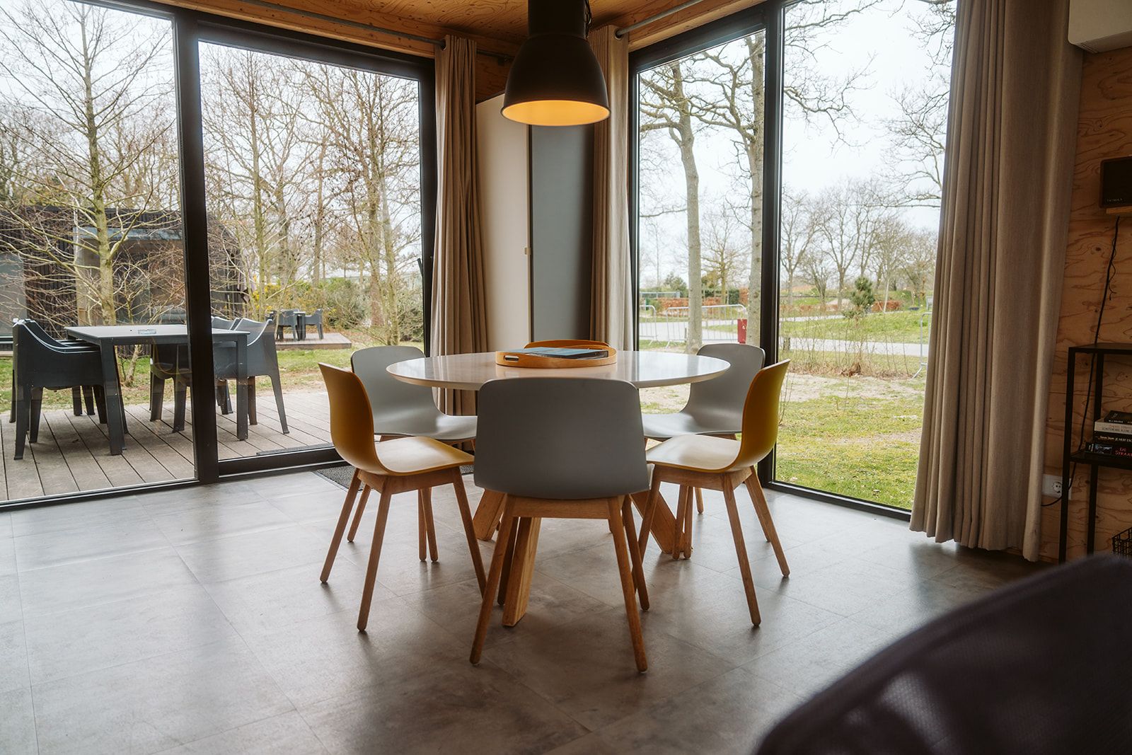 Dining area in Duunroos vacation home, Ouddorp, overlooking terrace and garden.