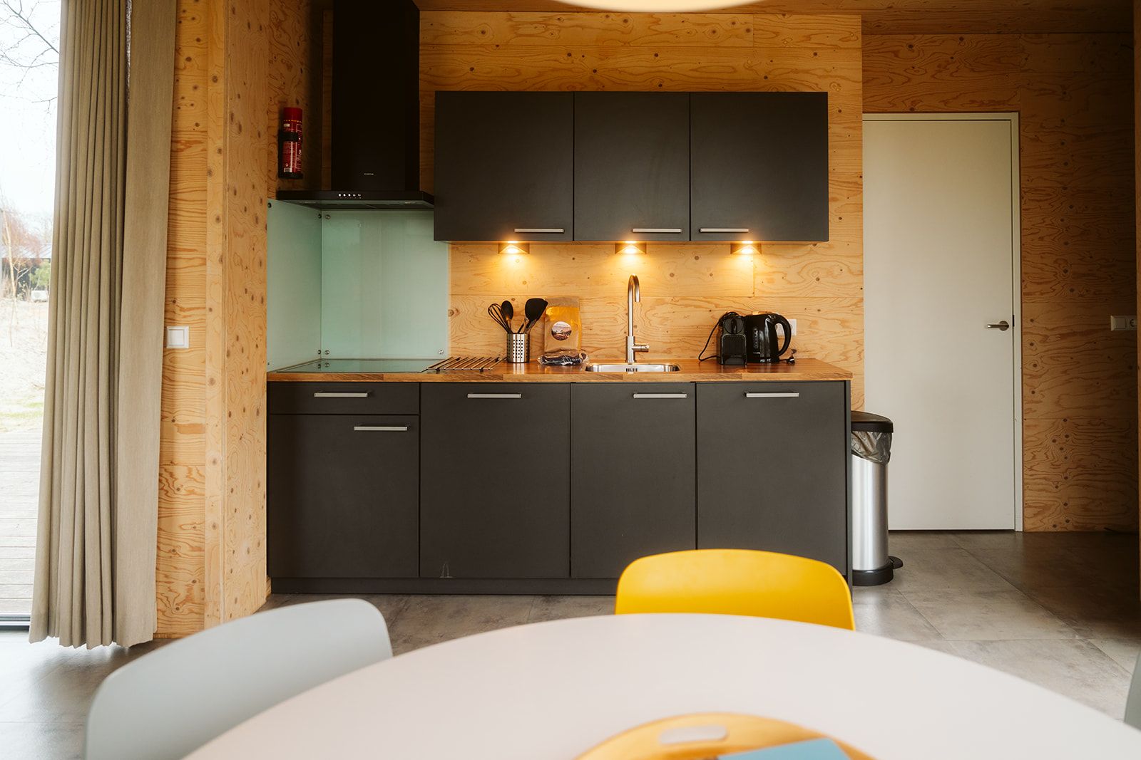 Kitchen in Duunroos vacation home, Ouddorp, with modern appliances and wooden finish.