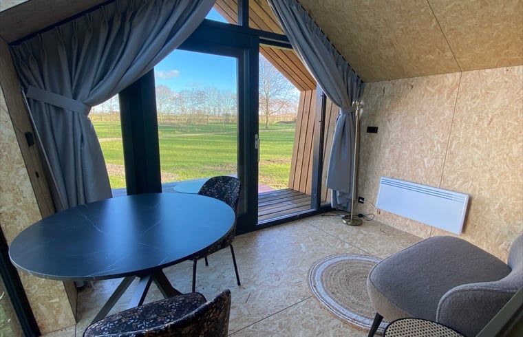 Innenansicht des Ferienhauses in Sommelsdijk mit Blick auf gruene Felder in Suedholland.