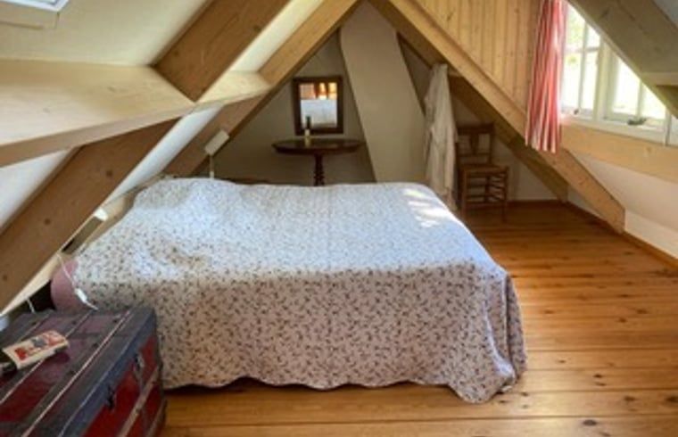 Attraktives Schlafzimmer im Dachgeschoss eines Ferienhauses in Goedereede mit Holzausstattung.