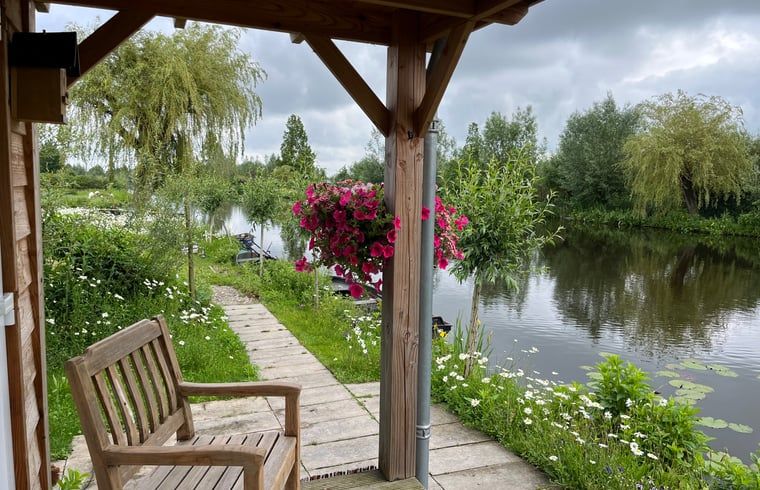 Veranda van Vakantiehuis in Reeuwijk met uitzicht op de serene natuur van het Groene Hart in Zuid-Holland.