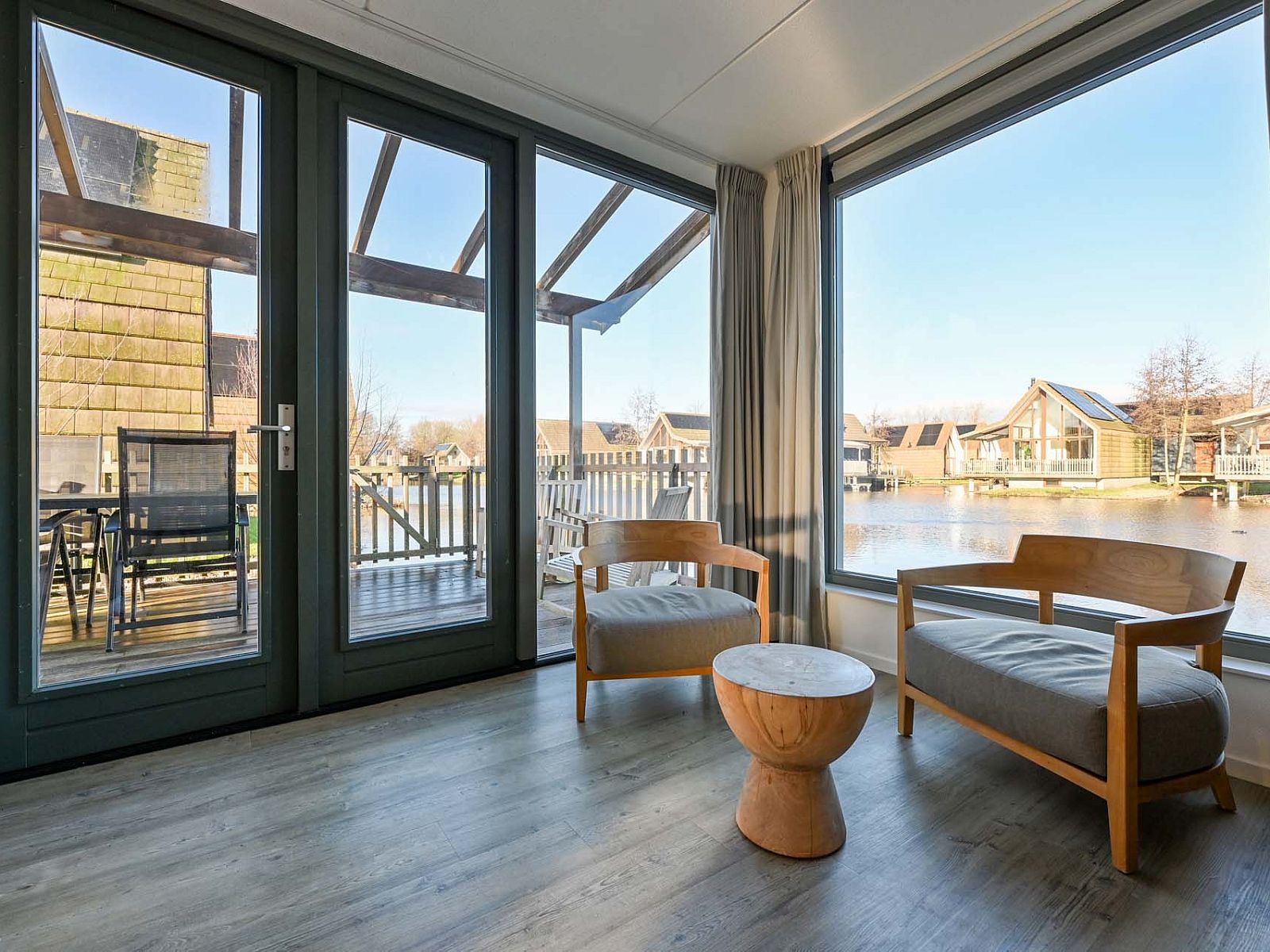 Lichte woonkamer in de vrijstaande woning in Reeuwijk met uitzicht op het water, vakantiehuis in Zuid-Holland.