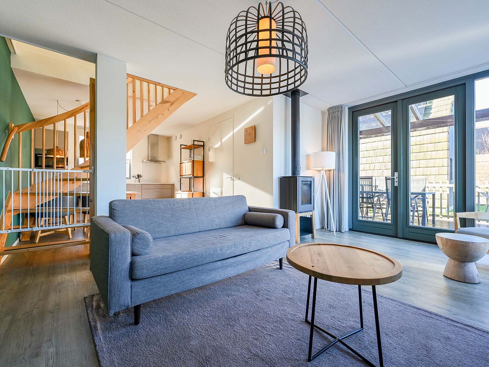 Gezellige woonkamer in vakantiehuis Reeuwijk, met moderne inrichting en uitzicht op het terras.