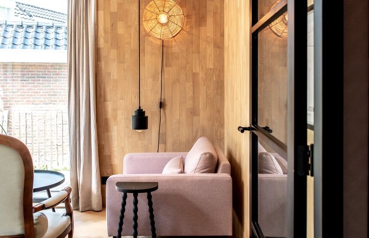 Gezellige binnenruimte van Vakantiehuisje in Reeuwijk, Zuid-Holland, met stijlvolle zithoek en houten wand voor een ontspannen verblijf.