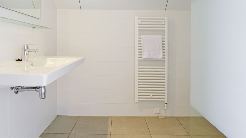 Badkamer met wastafel en handdoekradiator in De Reeuwijkse Plassen 2-persoons waterwoning 2C, Reeuwijk, Zuid-Holland.