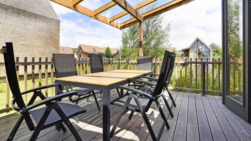 Grote veranda van De Reeuwijkse Plassen 6-persoons kinderwoning 6CK2 in Reeuwijk, met uitzicht op het park.