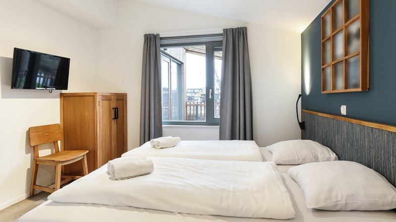 Slaapkamer met twee bedden in De Reeuwijkse Plassen 6-persoons kinderwoning 6CK2, Reeuwijk, met uitzicht op veranda.