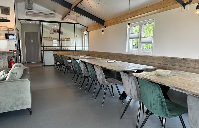 Stilvoller Essbereich im Ferienhaus in Gouderak, Green Heart, mit Holztischen und bequemen Stuehlen fuer ein gemuetliches Beisammensein.