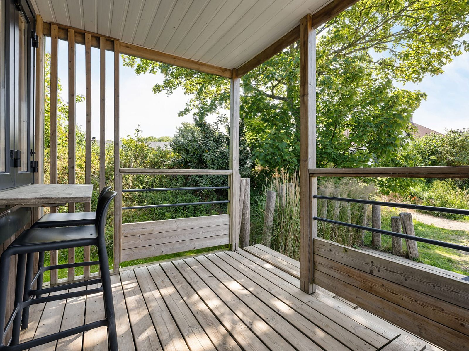 Die Terrasse des Mobilheims Beachhome in Ouddorp bietet einen herrlichen Blick auf die gruene Umgebung von Goeree-Overflakkee, Suedholland.