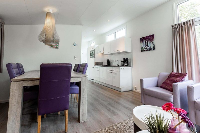 Stijlvolle eetkamer in Rialto 5 personen vakantiehuis in Nieuwerkerk aan den IJssel, Rotterdam met paarse stoelen en open keuken.