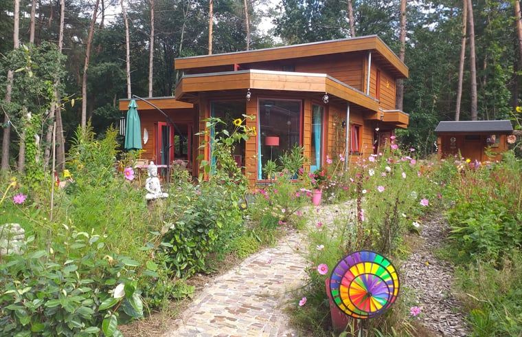 Vakantiehuisje in Groesbeek omringd door kleurrijke bloemen in het Rijk van Nijmegen, Gelderland.