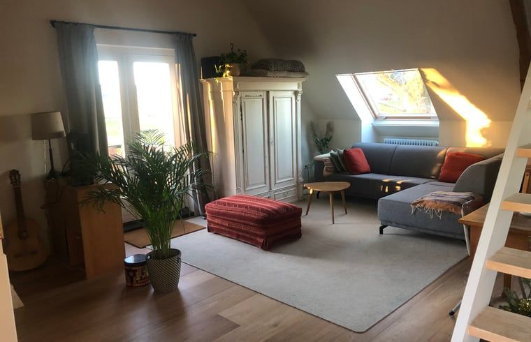 Gezellige woonkamer in Vakantiehuisje in Groesbeek, Rijk van Nijmegen, met comfortabele zithoek en veel natuurlijk licht.