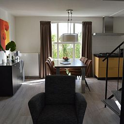 Gezellige eetkamer in Bungalow 543, De Cocksdorp, Texel. Geniet van een moderne binnenruimte met natuurlijk licht en een stijlvolle keuken.