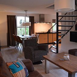 Comfortabele woonkamer in Bungalow 543, De Cocksdorp, Texel. Ontspan in een sfeervolle omgeving met open keuken en moderne inrichting.