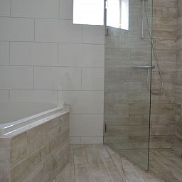 Moderne badkamer in Bungalow 543, De Cocksdorp, Texel. Luxe voorzieningen met inloopdouche en ligbad voor ultiem comfort.