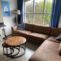 Cozy living room of Krim 661 with sauna, Stuha, and BBQ in De Cocksdorp, Texel. Comfortable bungalow with spacious sitting area and view of nature.