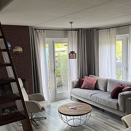 Stijlvolle woonkamer in TXL Huisje 299, vakantiehuis in De Cocksdorp, Texel, met moderne inrichting en veel natuurlijk licht.